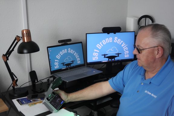 581 Drone Services aerial photographer operating drone flight controls